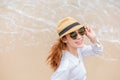 Smiling young woman in sun hat and waring sun glasses on the  beach. summer, holidays, vacation, travel concept Royalty Free Stock Photo