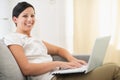 Smiling young woman surfing net on laptop Royalty Free Stock Photo