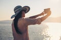 Smiling young woman take a selfie photo by the sea Royalty Free Stock Photo