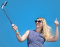 Smiling young woman taking selfie with smartphone on beach