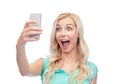 Smiling young woman taking selfie with smartphone Royalty Free Stock Photo