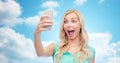 Smiling young woman taking selfie with smartphone Royalty Free Stock Photo