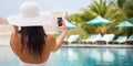 Smiling young woman taking selfie with smartphone