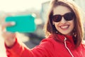 Smiling young woman taking selfie with smartphone Royalty Free Stock Photo