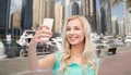 Smiling young woman taking selfie with smartphone Royalty Free Stock Photo