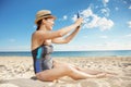 Smiling young woman taking selfie with tablet PC on beach Royalty Free Stock Photo