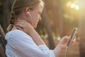 Smiling young woman or teenage girl with smartphone and headphones listening to music outdoors Royalty Free Stock Photo