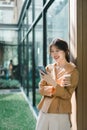 Smiling young woman texting on smartphone with coffee in urban setting. Royalty Free Stock Photo