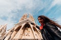 Smiling young woman tourist taking photos with smartphone in front of the famous Sagrada Familia catholic cathedral. Tourism in