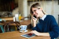 Smiling young woman using digital tablet at coffee shop Royalty Free Stock Photo