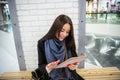 Smiling young woman using digital tablet at the mall Royalty Free Stock Photo
