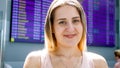 Portrait of smiling young woman waiting fro flight in international airport terminal Royalty Free Stock Photo