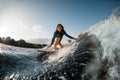 Smiling young woman wakesurfing down the river waves Royalty Free Stock Photo