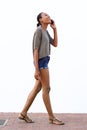 Smiling young woman walking and talking on cell phone Royalty Free Stock Photo