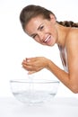 Smiling young woman washing face in glass bowl with water Royalty Free Stock Photo