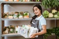 Smiling young woman wearing apron carrying basket of vegetables Royalty Free Stock Photo