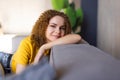 Smiling young woman wearing casual clothes relaxing on a couch at home Royalty Free Stock Photo