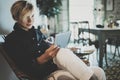 Smiling young woman wearing casual clothes and using electronic device while spending relax time home livingroom