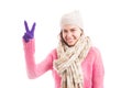 Woman wearing winter season clothes showing peace gesture
