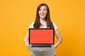 Smiling young woman in white casual clothes holding laptop pc computer with blank empty screen isolated on bright yellow Royalty Free Stock Photo