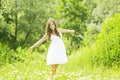 Smiling young woman in white dress against background of summer green park. Beautiful healthy happy girl enjoying freedom outside Royalty Free Stock Photo