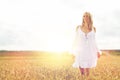 Smiling young woman in white dress on cereal field Royalty Free Stock Photo