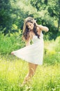 Smiling young woman in white dress with flower against background of summer green park. Royalty Free Stock Photo