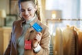 Woman trying coat with sale price tag and holding credit card Royalty Free Stock Photo