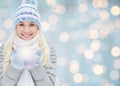 Smiling young woman in winter clothes over lights Royalty Free Stock Photo