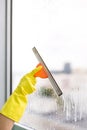 Worker cleaning soap suds on glass window with squeegee and rag Royalty Free Stock Photo