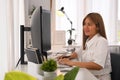 Smiling young woman working on software development on desktop computer at modern office Royalty Free Stock Photo