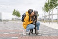 Smiling young woman in yellow hoodie hugging her fluffy shaggy gray dog, pet love and walking dog Royalty Free Stock Photo