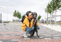 Smiling young woman in yellow hoodie hugging her fluffy shaggy gray dog, pet love and walking dog Royalty Free Stock Photo