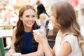 Smiling young women with coffee cups at cafe