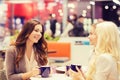 Smiling young women drinking coffee in mall Royalty Free Stock Photo