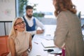 Smiling woman enjoys work talking to colleagues.Casual business at modern office Royalty Free Stock Photo