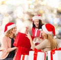 Smiling young women in santa hats with gifts Royalty Free Stock Photo