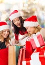 Smiling young women in santa hats with gifts Royalty Free Stock Photo