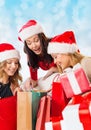 Smiling young women in santa hats with gifts Royalty Free Stock Photo