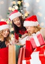 Smiling young women in santa hats with gifts Royalty Free Stock Photo