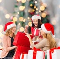 Smiling young women in santa hats with gifts Royalty Free Stock Photo