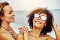 Smiling young women wearing bikinis standing on a tropical beach Royalty Free Stock Photo