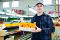 Smiling young worker with box of mandarins at sorting line Royalty Free Stock Photo