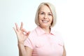 Smilling attractive middle aged woman showing thumbs up, okay. Isolated