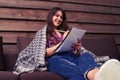 Smilling girl writing in a notebook while sitting on the sofa at Royalty Free Stock Photo