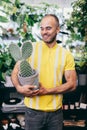 Smilling man with cactus in florist shop Royalty Free Stock Photo