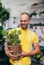 Smilling man with cactus in florist shop Royalty Free Stock Photo