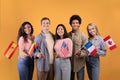 Smillinge multi ethnic student in casual, hold small flags