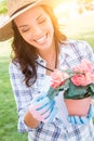 Smilng Adult Woman Wearing Hat and Gloves Gardening Outdoors