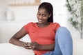 Smilng Young Black Woman Messaging On Smartphone While Relaxing At Home